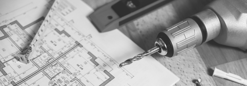 Un plan de maison, une perceuse, un mètre et un niveau